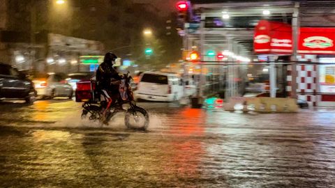 Lieferfahrer auf einem Fahrrad im Regen von New York
