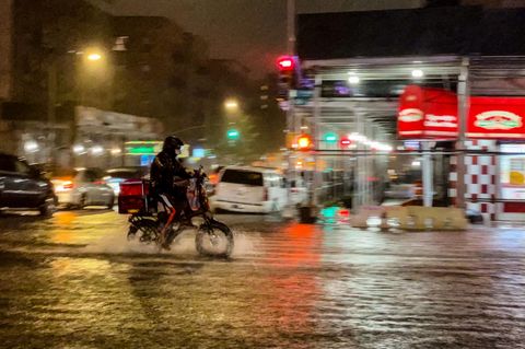 Lieferfahrer auf einem Fahrrad im Regen von New York