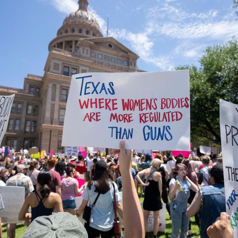 Demonstrant:innen halten Schilder vor dem State Capitol in Austin, Texas hoch