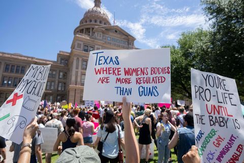 Demonstrant:innen halten Schilder vor dem State Capitol in Austin, Texas hoch
