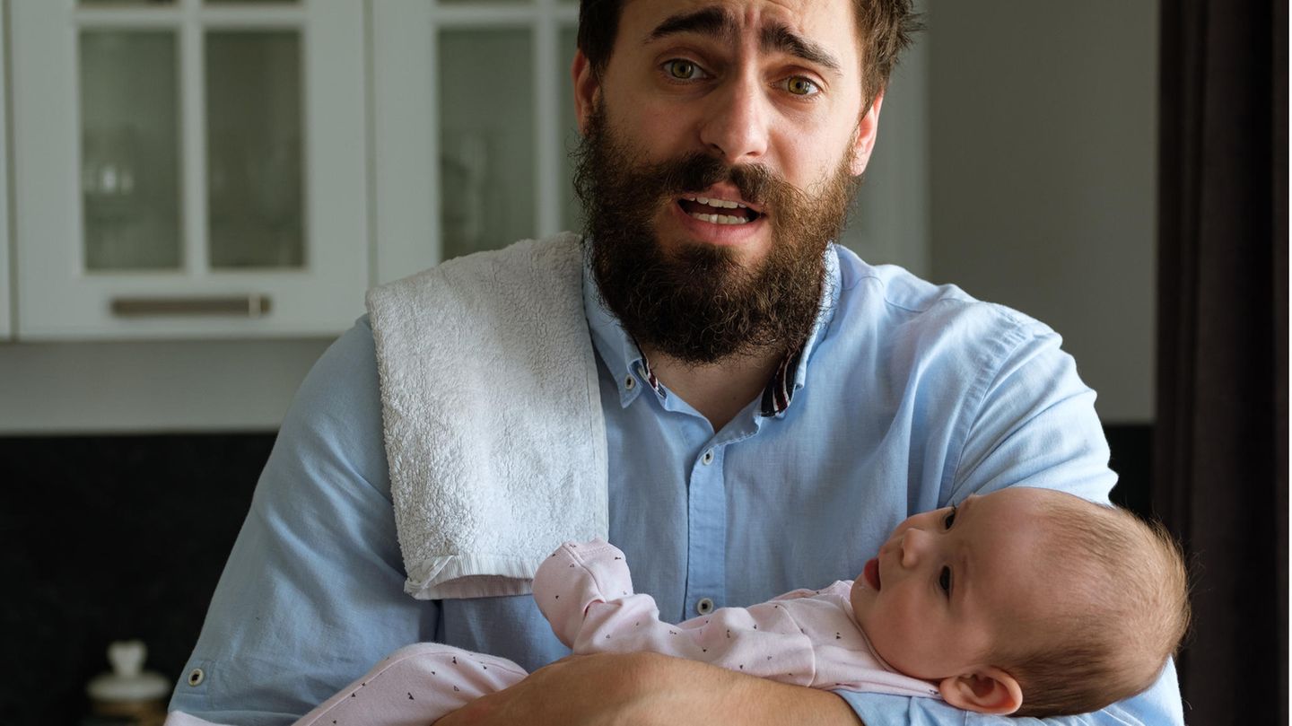 Ein verzweifelter Vater mit einem weinenden Baby