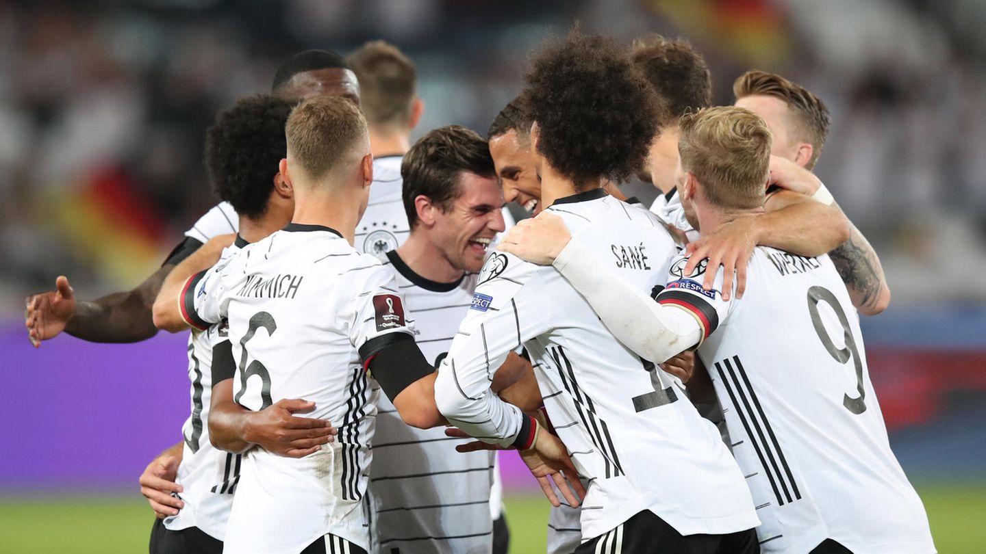 In weißen Trikots und schwarzen Hosen bilden alle zehn Feldspieler des DFB-Teams eine Jubeltraube um den Torschützen