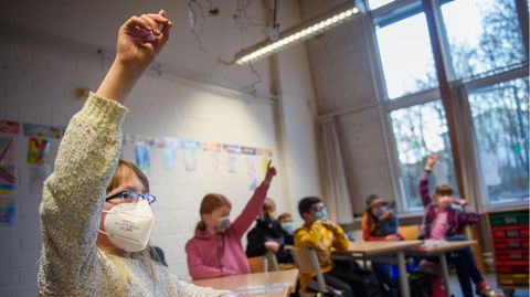 Eine Schülerin einer 4. Klasse hebt im Unterricht an der Grundschule Russee in Kiel die Hand