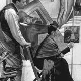 Diego Rivera beobachtet Frida Kahlo beim Malen von "Selbstbildnis (auf der Grenze zwischen Mexiko und den USA)" im Detroit Institute of Arts, 1932