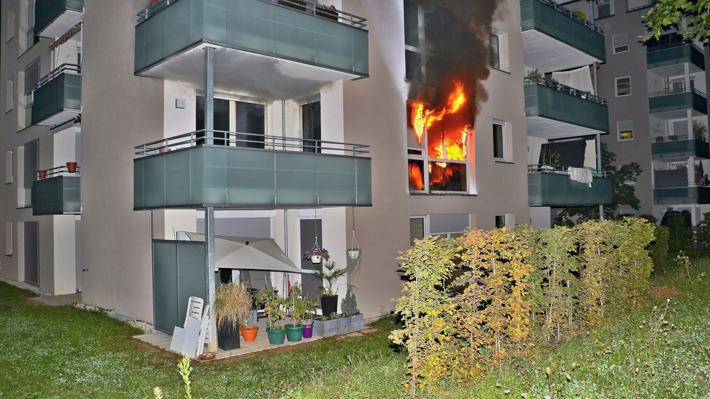 Flammen schlagen aus dem Fenster eines Mehrfamilienhauses in Stuttgart.