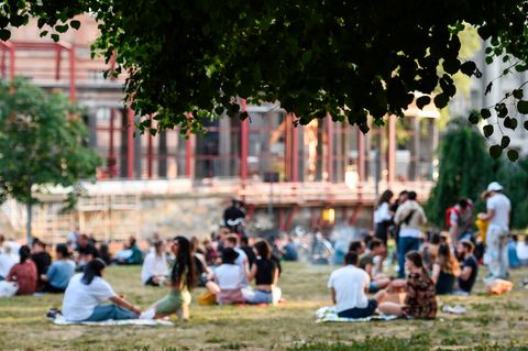 Neue Corona-Richtwerte Inzident Hospitalisierungsrate: Personen sitzen in einem Berliner Park