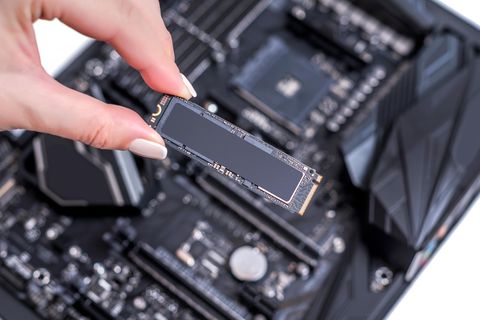 M.2-SSD: Eine weibliche Hand hält einen M.2-SSD-Riegel in der Hand.