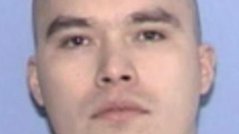 Ein weißer Mann mit kahl rasiertem Schädel und braunen Augen schaut direkt geradeaus