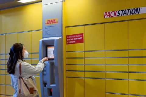 Frau bedient eine Packstation