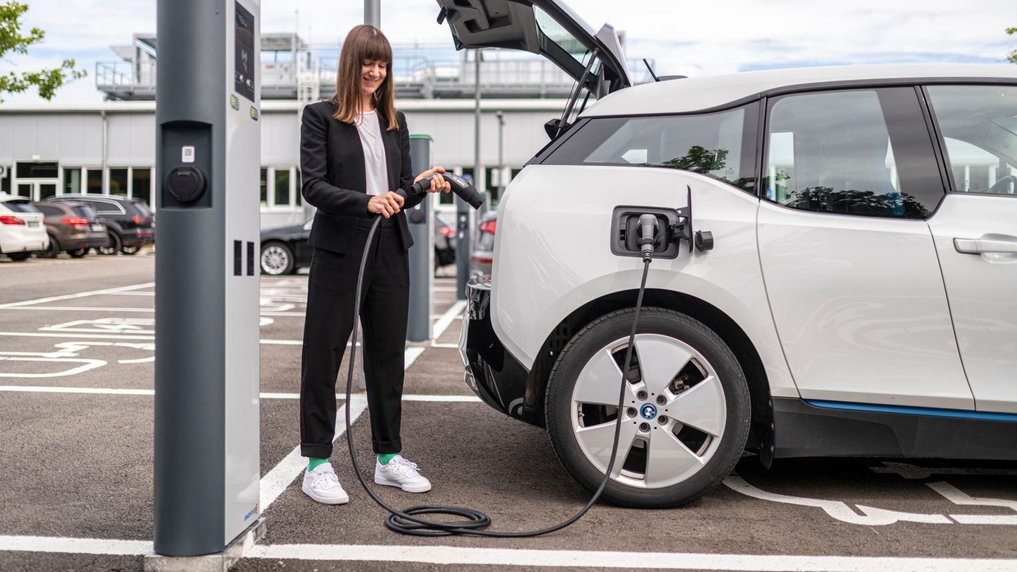 Autofahrerin lädt ihr Elektroauto an einer Ladesäule