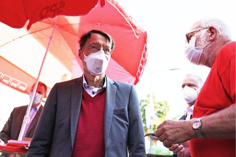 Karl Lauterbach (M) steht im Kölner Stadtteil Delbrück am SPD-Stand