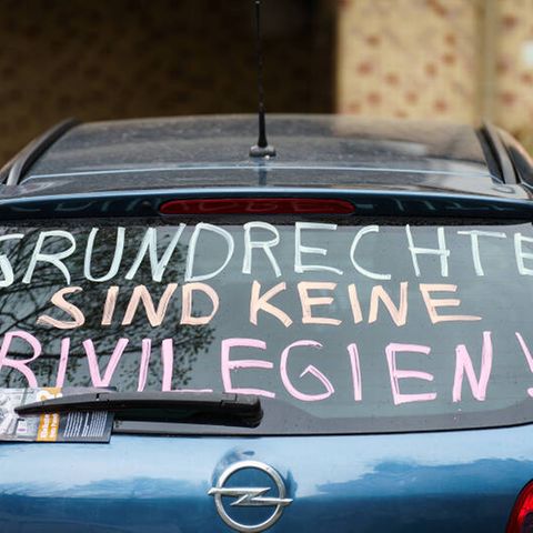 Die Heckscheibe eines PKW trägt die Parole ·Grundrechte sind keine Privilegien!·