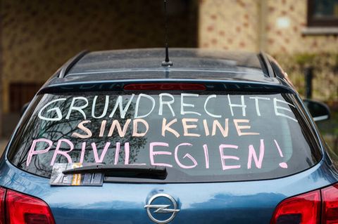 Die Heckscheibe eines PKW trägt die Parole ·Grundrechte sind keine Privilegien!·