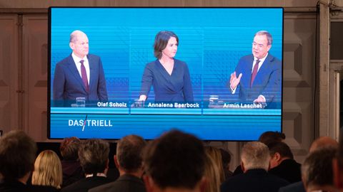 Kanzlerkandidat Olaf Scholz (SPD, l.), Kanzlerkandidatin Annalena Baerbock (Bündnis90/Die Grünen) und Kanzlerkandidat Armin Laschet (CDU) während des Triells auf einem Bildschirm in Berlin.