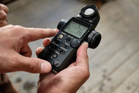 Ein Belichtungsmesser in der Hand eines Fotografen.