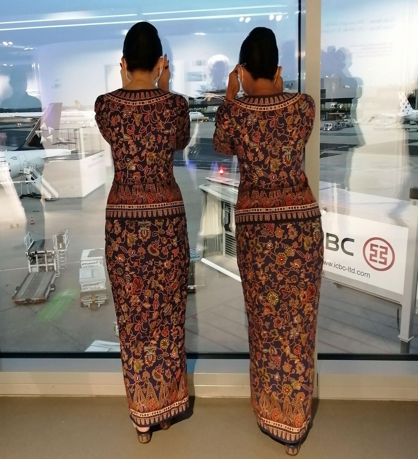 Am Frankfurter Flughafen: Zwei Flugbeleiterinnen beobachten gespannt die Ankunft der Boeing 777 für den Flug nach Singapur.