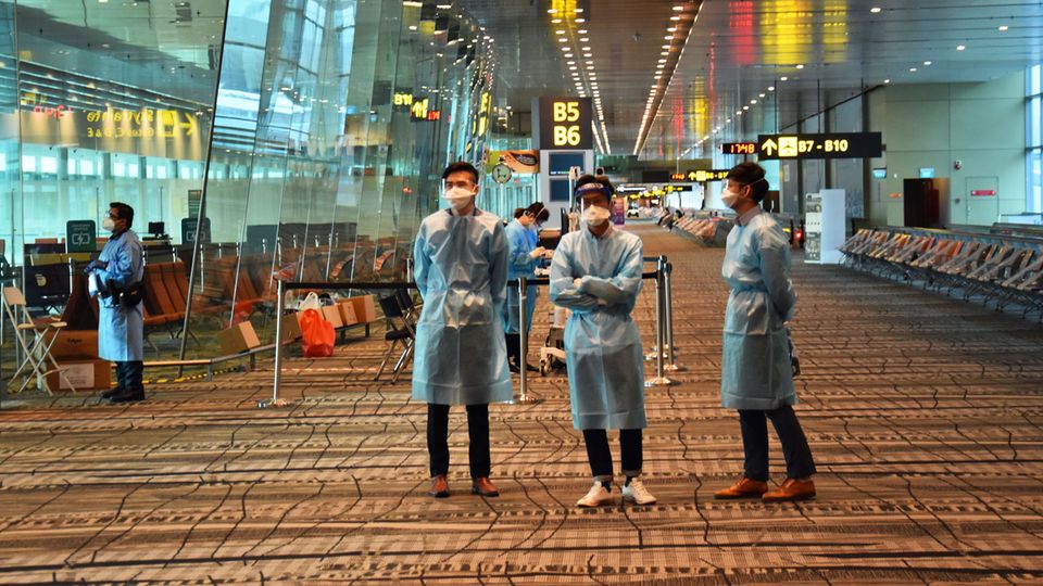 Vaccinated Travel Lane: Willkommen als einer von wenigen Flügen in Singapur: Helfendes Flughafenpersonal in Schutzkleidung steht an jeder Ecke und weist den Weg zum Testzentrum. Willkommen als einer von wenigen Flügen in Singapur: Helfendes Flughafenpersonal in Schutzkleidung steht an jeder Ecke und weist den Weg zum Testzentrum.
