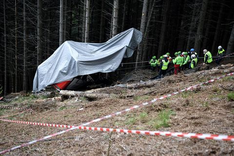 Einsatzkräfte des Bergrettungsdienstes arbeiten nach dem Absturz einer Seilbahngondel an der Unfallstelle