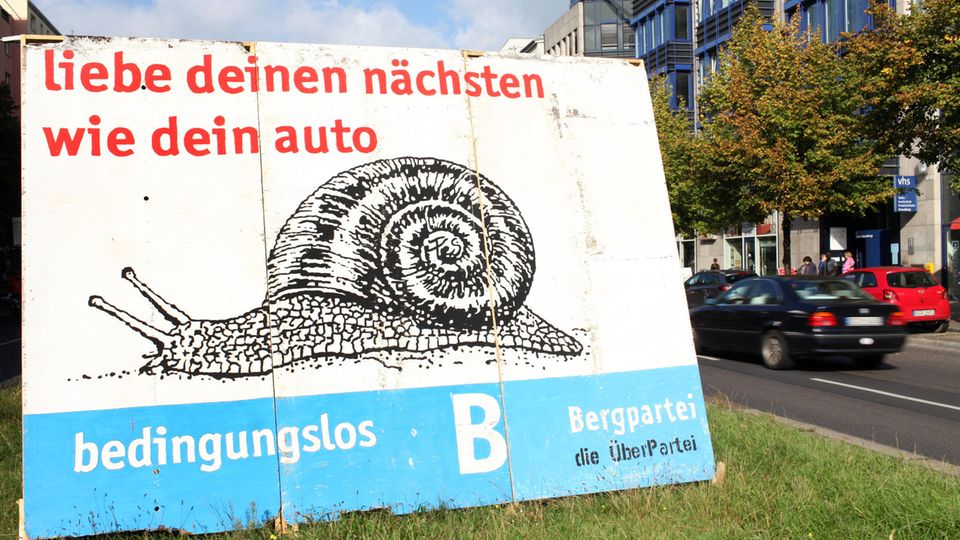 Ein Wahlplakat der Bergpartei mit dem Spruch "Liebe deinen nächsten wie dein Auto"