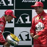 Schumacher verbeugt sich auf dem Siegertreppchen vor Teamkollege Rubens Barrichello