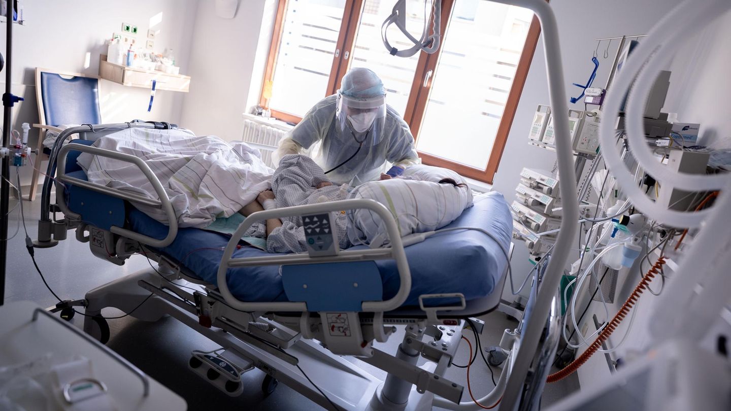 Hospitalisierungsinzidenz RKI: Ein Intensivpfleger kümmert sich um eine an Covid-19 erkrankte Patientin