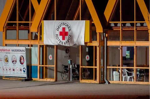 Eine Rot-Kreuz-Fahne hängt über dem Eingang zum Impfzentrum in Eich
