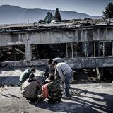 Geflüchtete vor einer ehemaligen Metallfabrik, in der sie leben