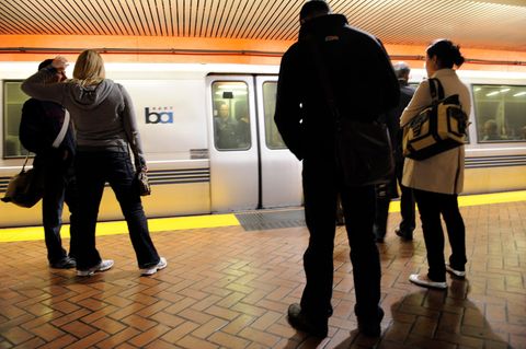 Menschen stehen an einem unterirdischen Bahnsteig