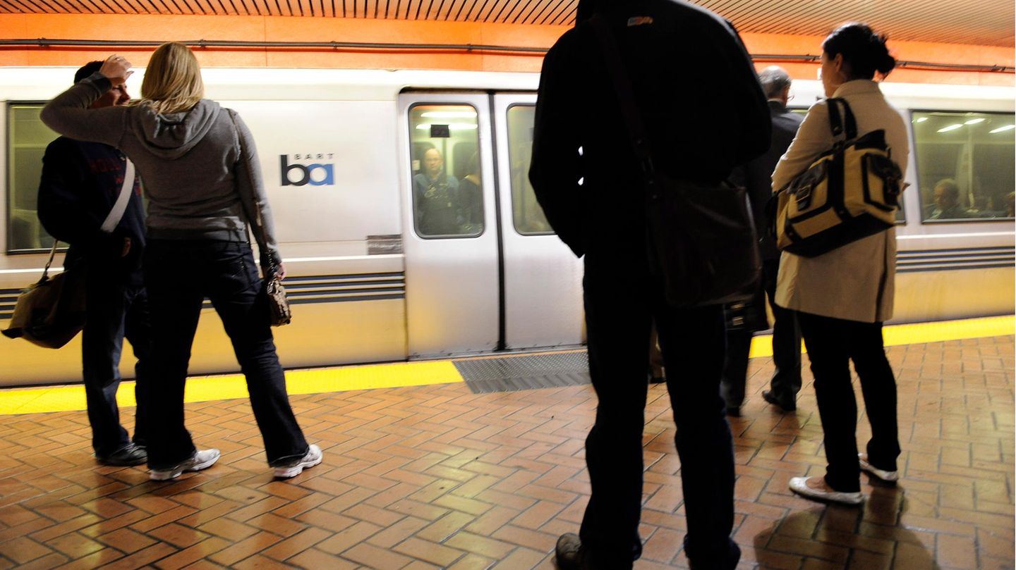 Menschen stehen an einem unterirdischen Bahnsteig