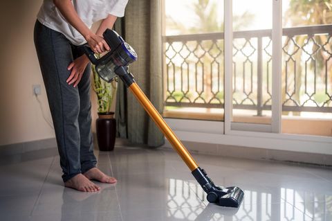 Dyson V10 Absolute: Ein Mann saugt mit seinem Akku-Sauger den Boden.