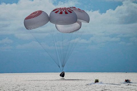 In diesem Bild aus einem SpaceX-Video gleitet eine SpaceX-Kapsel mit vier Personen an Bord vor der Küste Floridas mit Fallschirmen in den Atlantik.