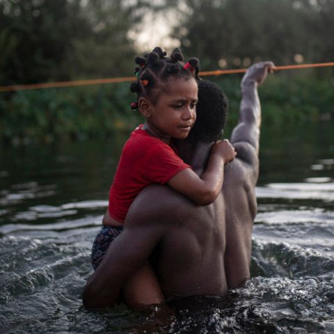 Ein Vater überquert mit seiner Tochter den Rio Grande
