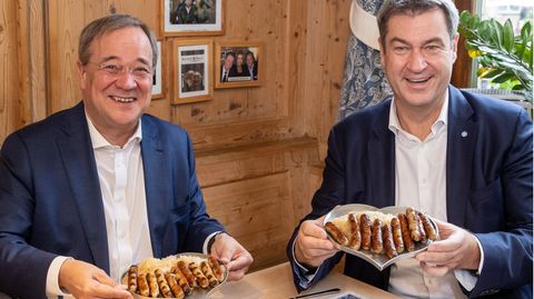 Armin Laschet und Markus Söder am Tisch mit einem Teller Nürnberger Würstchen