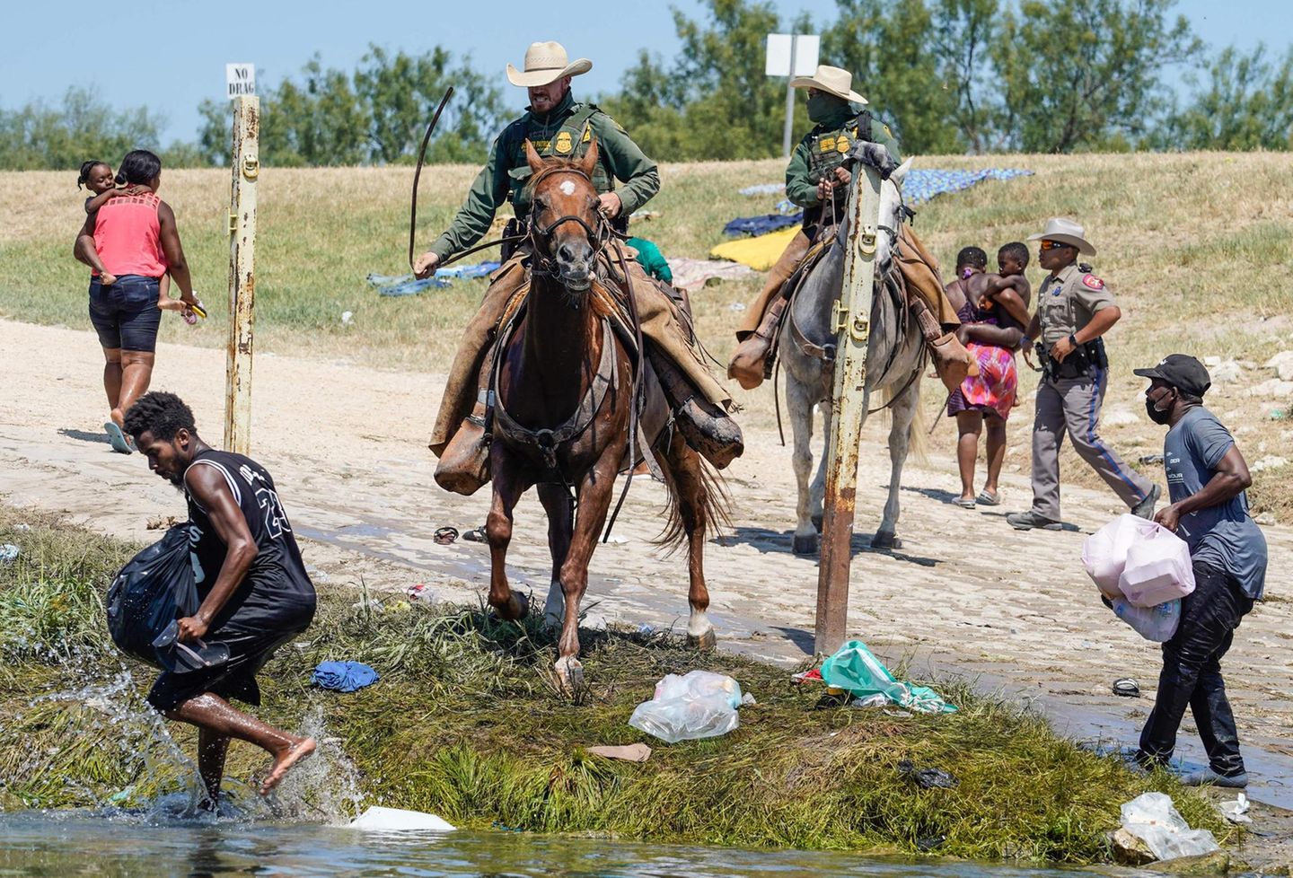 Berittene Beamte der US-Zoll- und Grenzschutzbehörde versuchen, haitianische Migranten aufzuhalten