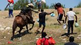 Ein berittener Beamter der US-Zoll- und Grenzschutzbehörde versucht, einen haitianischen Migranten aufzuhalten