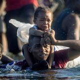 Mit einem Kleinkind auf den Schultern durchquert dieser haitianische Flüchtlinge den Rio Grande in Richtung Mexiko