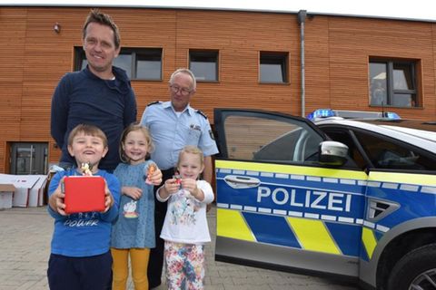 Polizeihauptkommissar Rainer Stach übergab die rote Erzählbox und drei Figuren an den stellvertretenden Leiter der Kita "Wundertüte", Marcel Rau, und drei Kinder