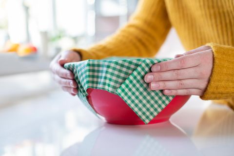 Bienenwachstücher: Frau verschließt Schüssel mit einem Bienenwachstuch