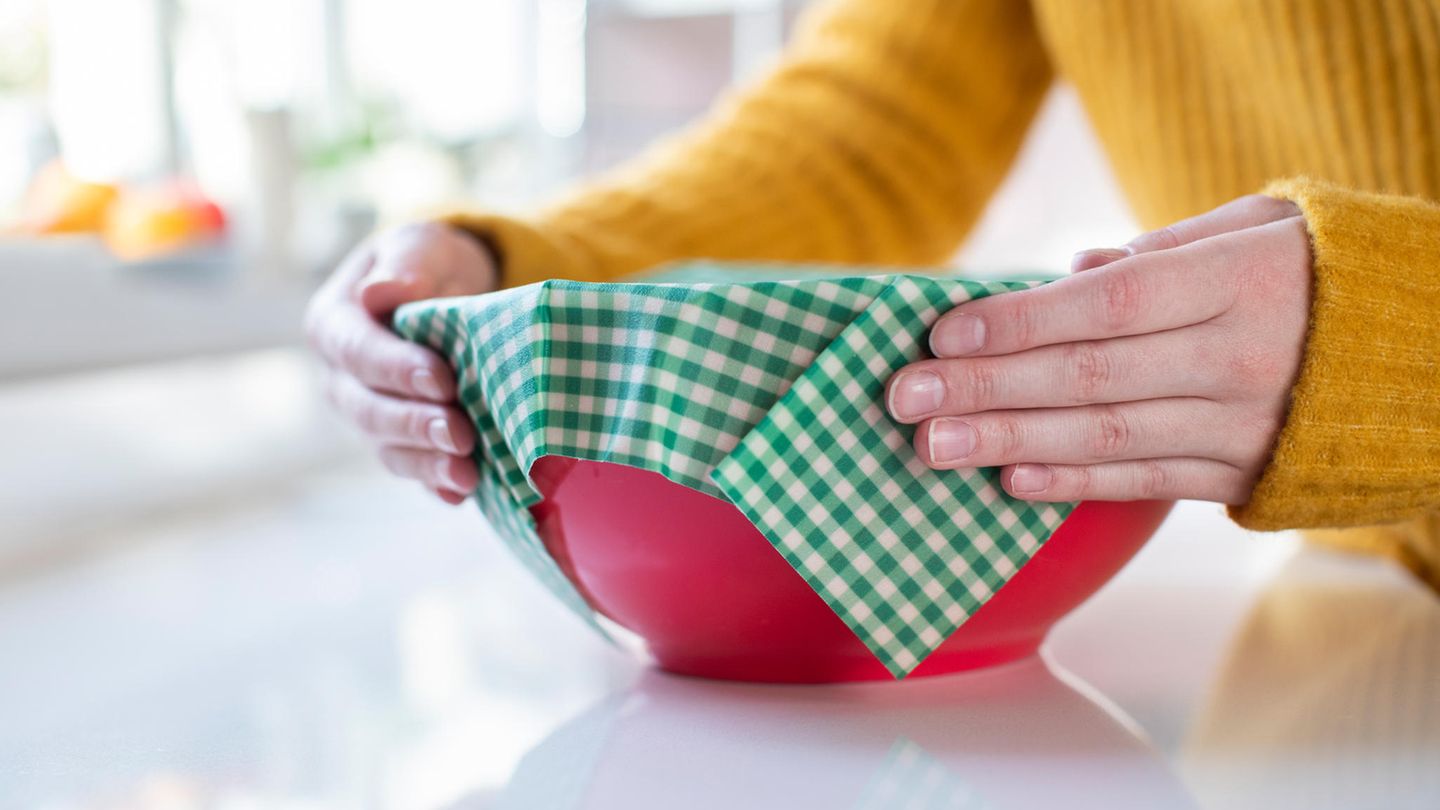 Bienenwachstücher: Frau verschließt Schüssel mit einem Bienenwachstuch