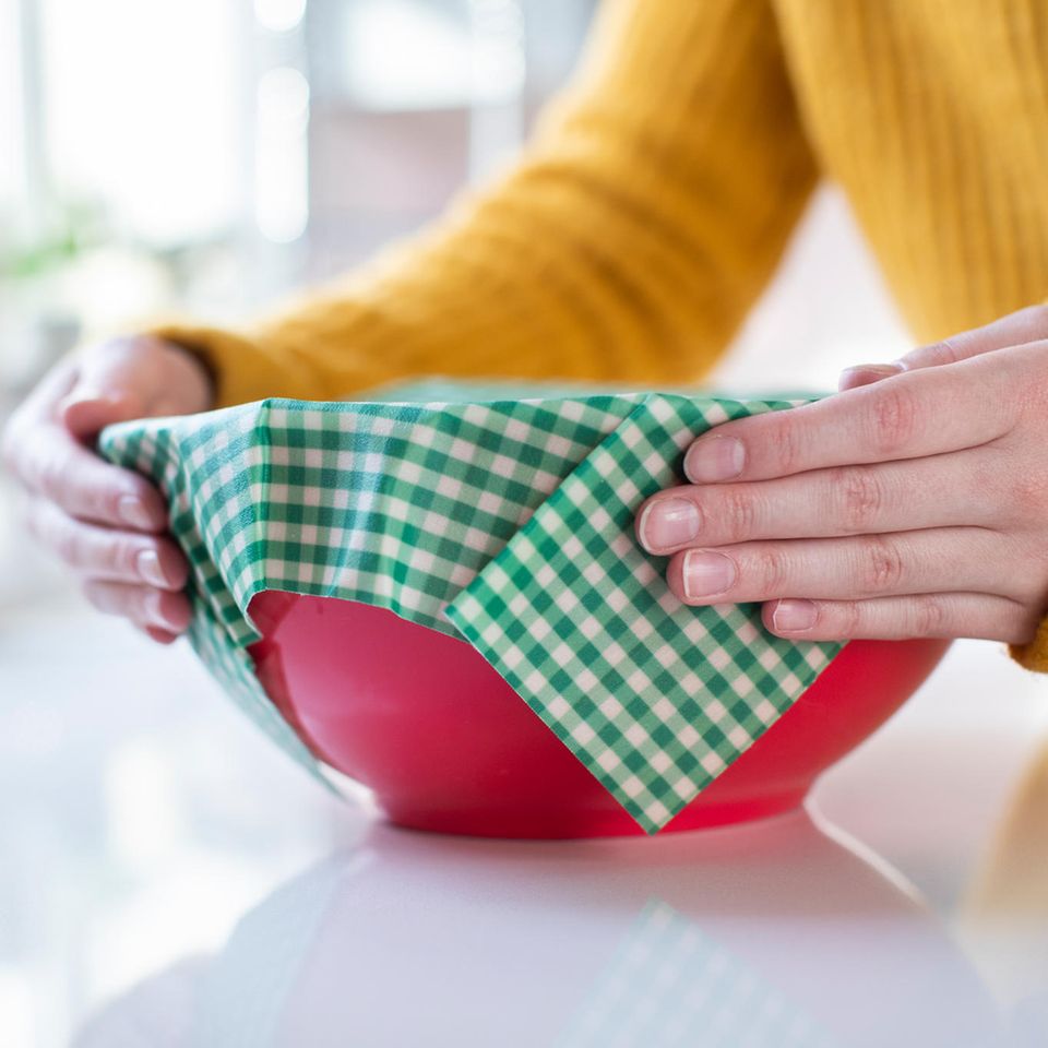 Bienenwachstücher: Frau verschließt Schüssel mit einem Bienenwachstuch