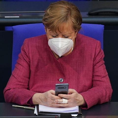 Angela Merkel schaut im Bundestag auf ihr Smartphone