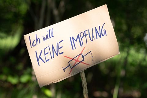 Ein Pappschild mit der Aufschrift "Ich will keine Impfung" und einer durchgestrichenen Spritze