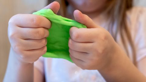 Intelligente Knete: Kinderhände spielen mit giftgrüner Knetmasse