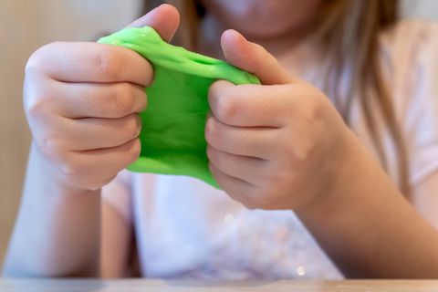 Intelligente Knete: Kinderhände spielen mit giftgrüner Knetmasse