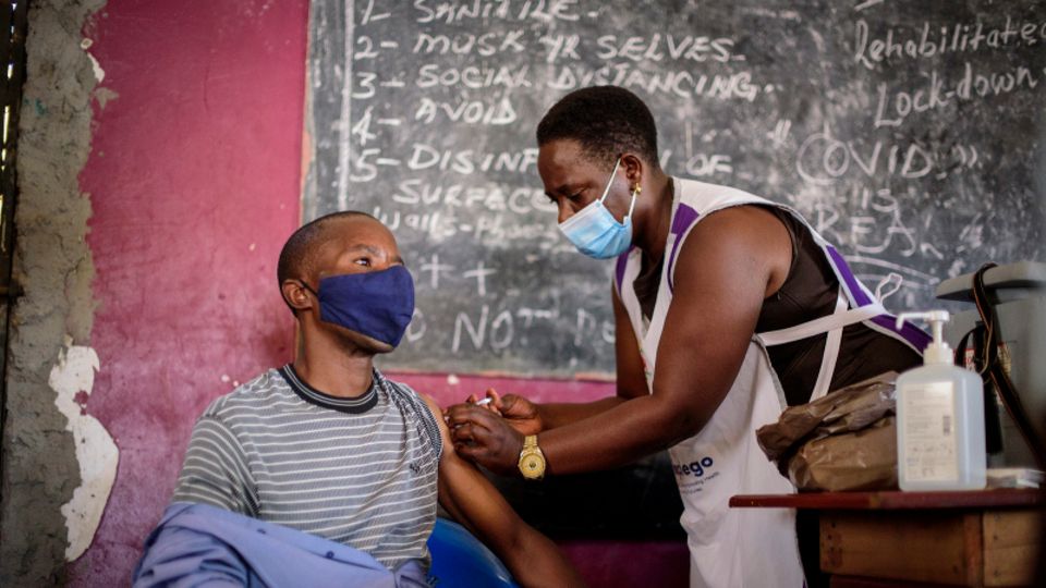 Uganda: Eine Krankenschwester verabreicht einem jungen Mann eine Impfung gegen das Coronavirus