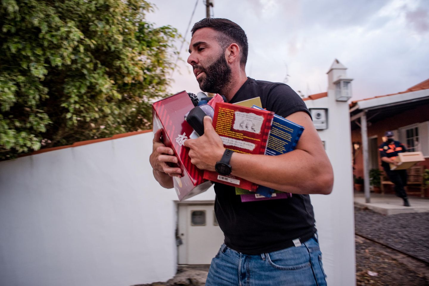 In aller Eile rettet dieser Mann noch schnell Kinderspielzeug und Bücher aus seinem Haus