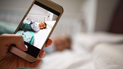 Mit dem Handy wird ein Foto vom Baby gemacht