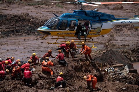 Feuerwehrleute und ein Helikopter bei der Dammbruch-Katastrophe in Brumadinho