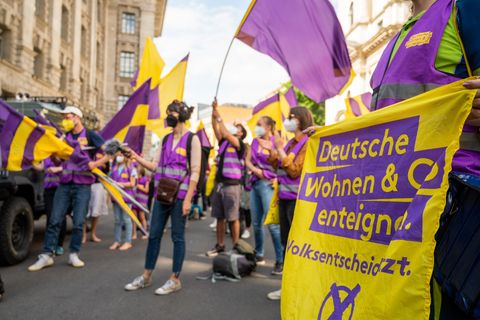 Unterstützer der Initiative "Deutsche Wohnen & Co. enteignen" schwenken im Juni in Berlin Fahnen