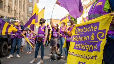 Unterstützer der Initiative "Deutsche Wohnen & Co. enteignen" schwenken im Juni in Berlin Fahnen